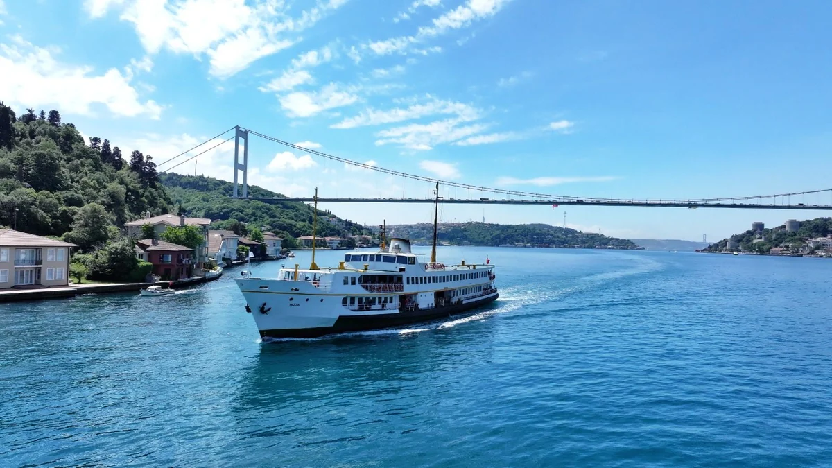 A Şehir Hatları ferry crossing the Bosphorus beneath a suspension bridge
