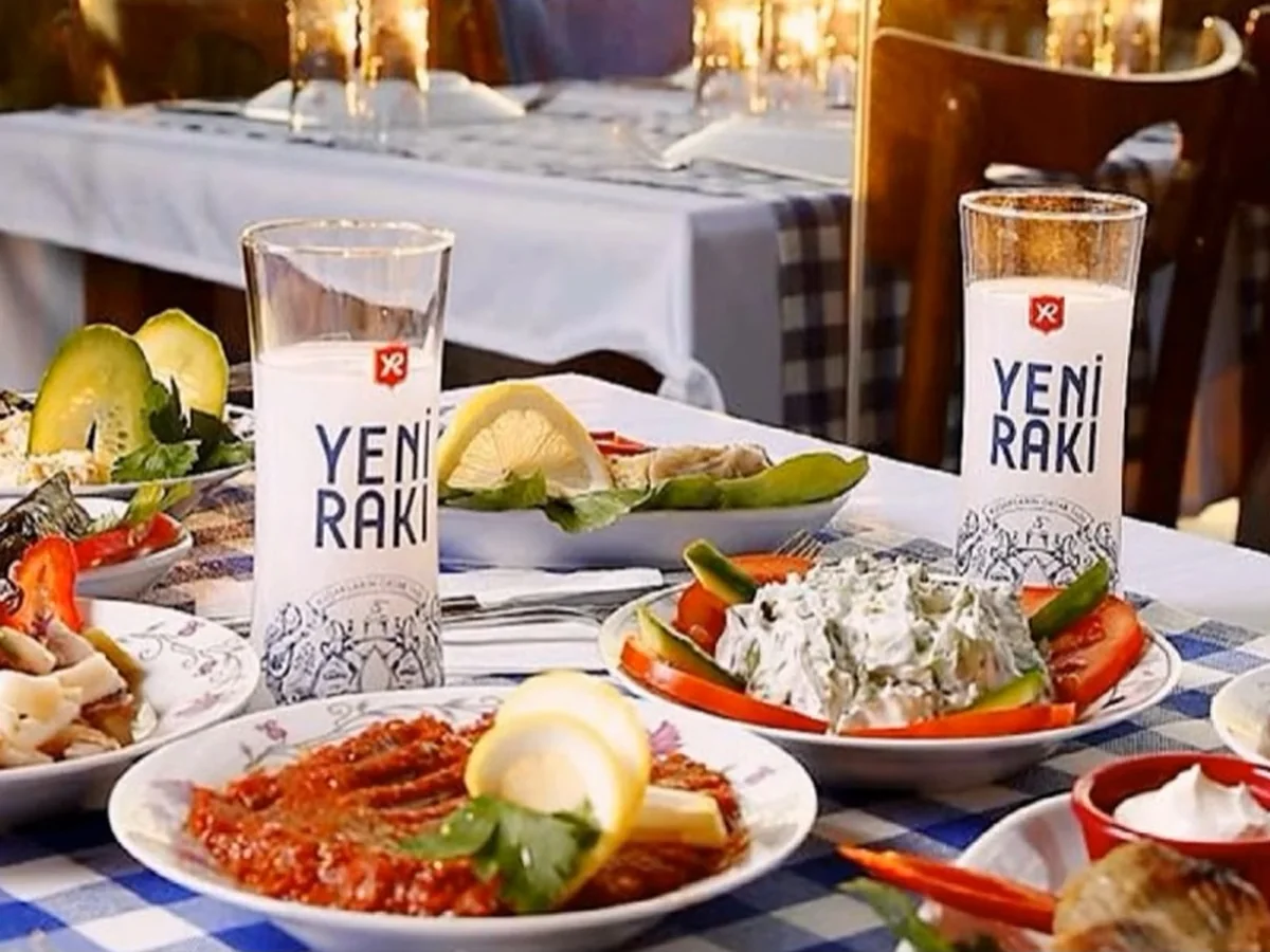 Two glasses of rakı beside assorted meze plates