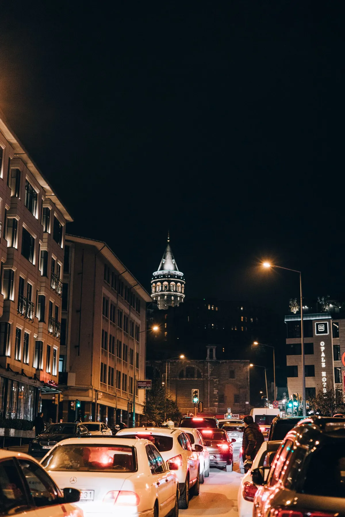 Illuminated Galata Tower above an Istanbul street at night