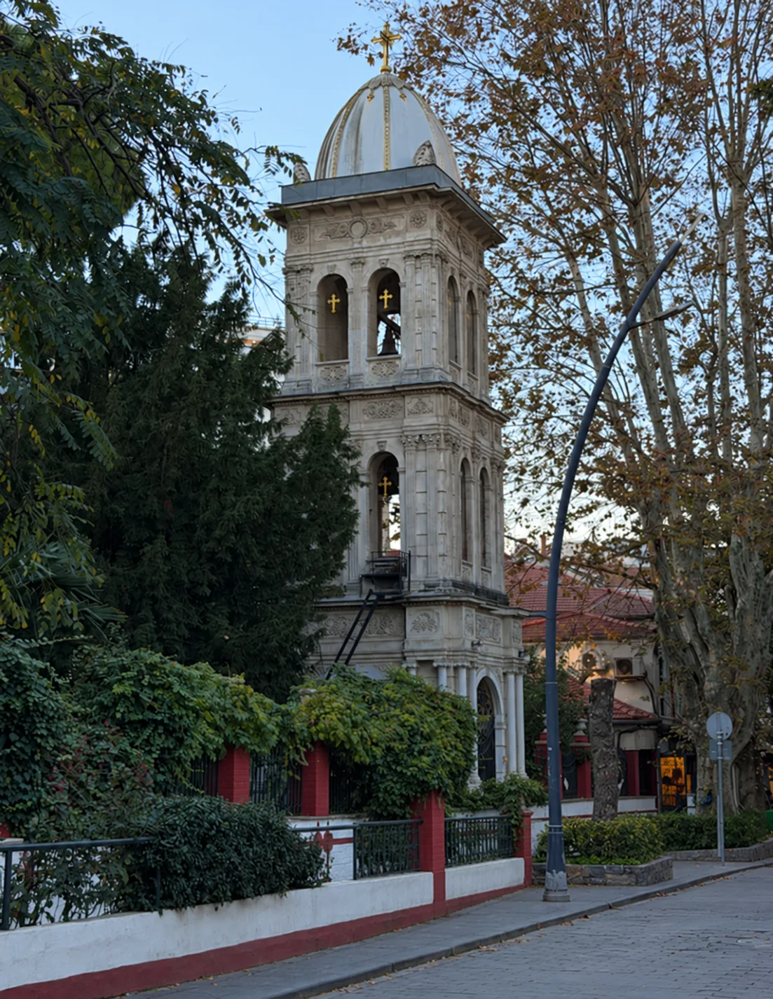 Der Glockenturm der Aya-Panteleimon-Kirche zwischen Bäumen, von der İcadiye Caddesi aus gesehen