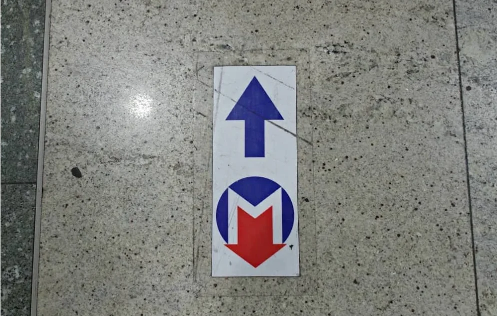 Metro symbol and directional arrow on the airport terminal floor