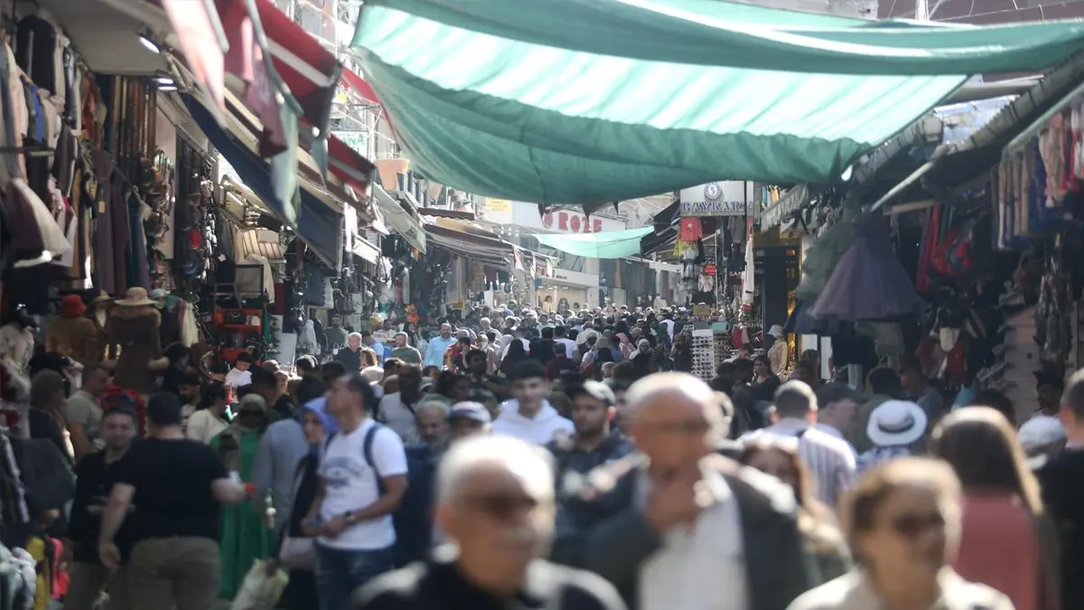 Crowds browsing a Mahmutpaşa market street beneath fabric awnings